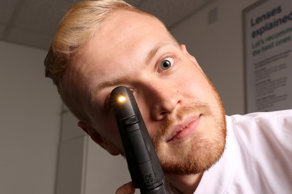 Man holding ophthalmoscope