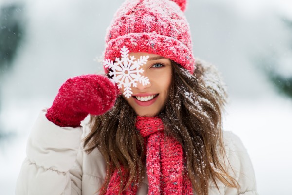 Woman in winter clothing holding snowflake